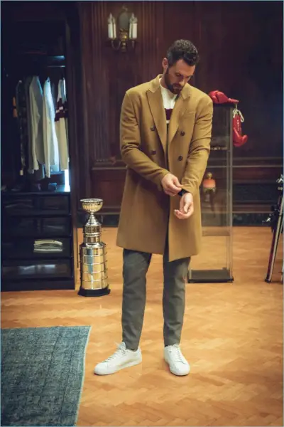 Abraçando o estilo universitário, Kevin Love veste um sobretudo trespassado, um suéter listrado e calças de lã de sua colaboração com a Banana Republic.