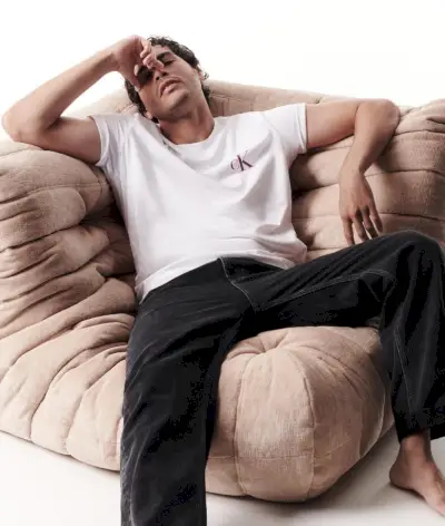 Nathan McGuire poartă un tricou CK și blugi negri pentru Calvin Klein