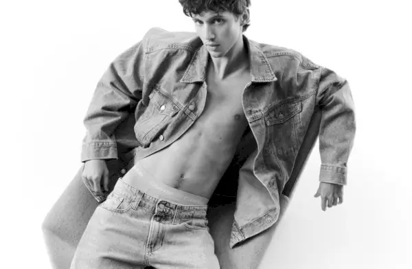 Apărând într-o fotografie alb-negru, Troye Sivan poartă o jachetă de blugi și blugi de blugi pentru Calvin Klein