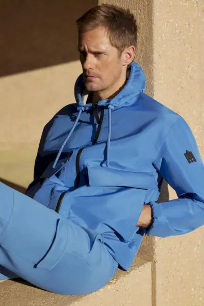 Faisant une déclaration dans une veste à capuche bleue, Alexander Skarsgård joue dans Mackage
