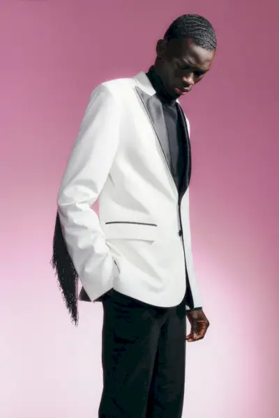 Kledd for å imponere, bærer Khadim Sock en hvit og svart smokingjakke for J.Lindeberg