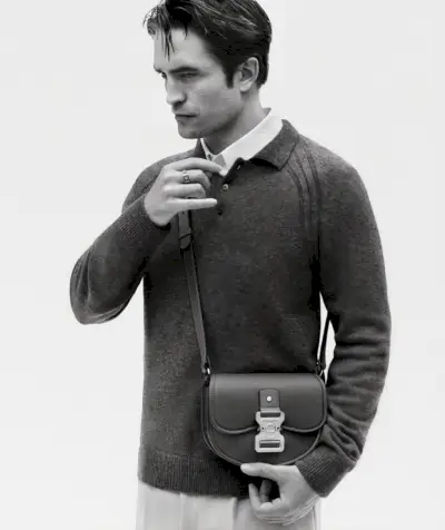 Ubrany w dzianinową koszulkę polo z długim rękawem i torbę na ramię Dior Gallop, Robert Pattinson występuje w reklamie Dior New Icons.