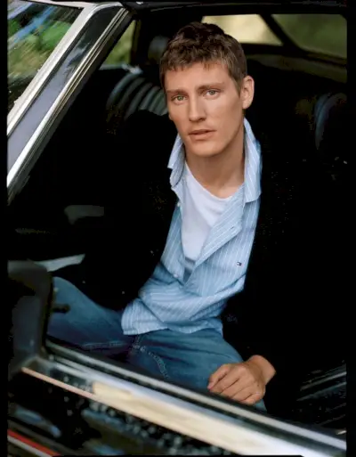 Mikkel Jensen har på seg en blazer og en oppkneppet skjorte som gir en avslappet, men sofistikert versjon av Tommy Hilfiger