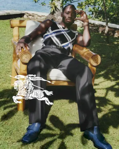 バーバリーのグラフィックトップスとテーラードパンツを着てくつろぐマラキ・スルー