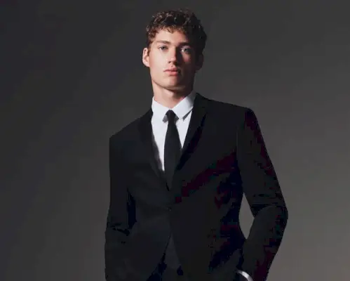 Valentin Humbroich utstrålar självförtroende i en elegant svart Calvin Klein-kostym med en klassisk vit skjorta och slips.