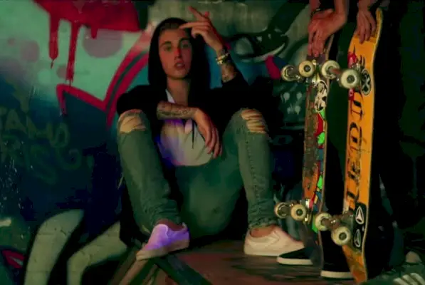 ジャスティン・ビーバーは、黒のパーカーと膝が破れたカルバン・クライン・ジーンズでカジュアルに着こなしています。