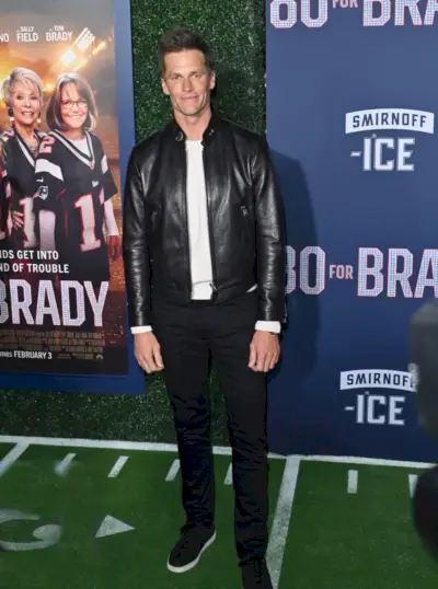 Tom Brady har på seg en Tom Ford skinnjakke, genser, jeans og joggesko til Los Angeles-premieren på 80 for Brady.