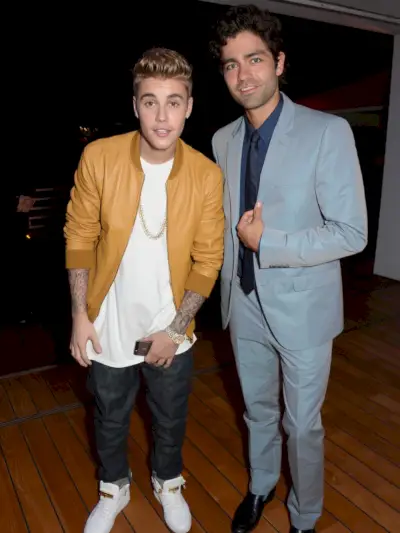 歌手のジャスティン・ビーバーと俳優のエイドリアン・グレニアーがポーズをとる。グルニエはイベント用のスーツを着ていたが、ビーバーは革製のボンバーを着たパーティークラッシャーのように見えた。