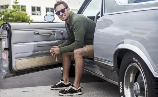 En modell är avbildad i Simple OS svarta sneakers.