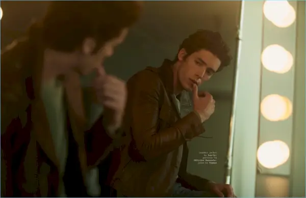 Pico Alexander kijkt naar zijn spiegelbeeld en draagt ​​een leren Lanvin-jack met een Officine Generale-trui en een Topman-spijkerbroek.