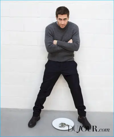 Croisant les bras, Jake Gyllenhaal porte un pull Margaret Howell avec un pantalon Hermès et des bottes Blundstone.