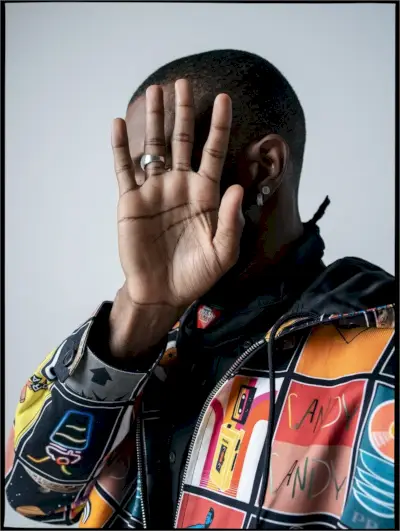 Susisiekęs su W žurnalu, Frankas Oušenas dėvi Prada marškinius, švarką, kaklaskarę ir karolius.