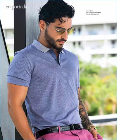I blød i solen bærer Maluma Ahlem-solbriller med polo og bukser fra Hugo Boss. Maluma har også et Saint Laurent-bælte.