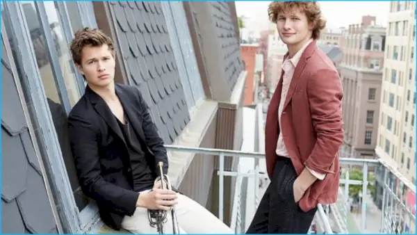 Ansel Elgort nosí sako Burberry, tank Tomas Maier a nohavice Gucci. Warren nosí sako Boglioli, košeľu Alex Mill a nohavice Wooyoungmi.