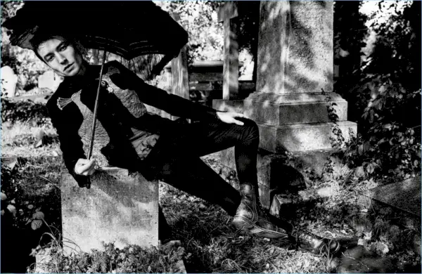 En un cementerio, Ezra Miller lleva una chaqueta y aretes de Alexander McQueen. El actor también viste una camisa de Ann Demeulemeester, pantalones Dolce & Gabbana y botas Frye.