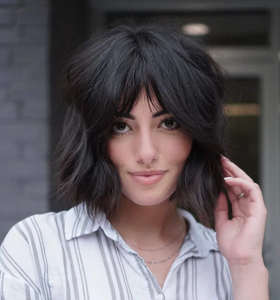 Lek med den hakelange shag-kuttet ved å pare den med midtdelt pannelugg. En frisyre som denne krever en bestemt hårtetthet. For skjønnheter med tykke lokker er dette perfekt! Når du styler jazz det opp med myke bølger. Det er slik du oppnår uanstrengt skjønnhet.' title=