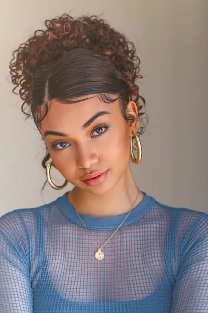 Kučeravý drdol s elegantnou bočnou časťou a definovanými detskými vláskami pre moderný nádych' title=