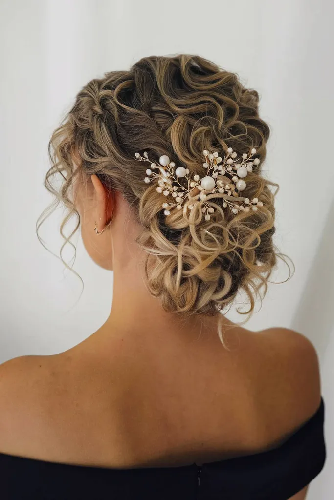 Kučeravý drdol s ozdobnými šperkami do vlasov zdobenými perlami pre sofistikovaný vzhľad' title=