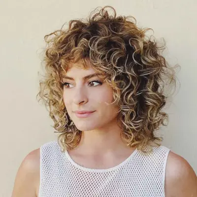 curly shoulder-length beige blonde bob