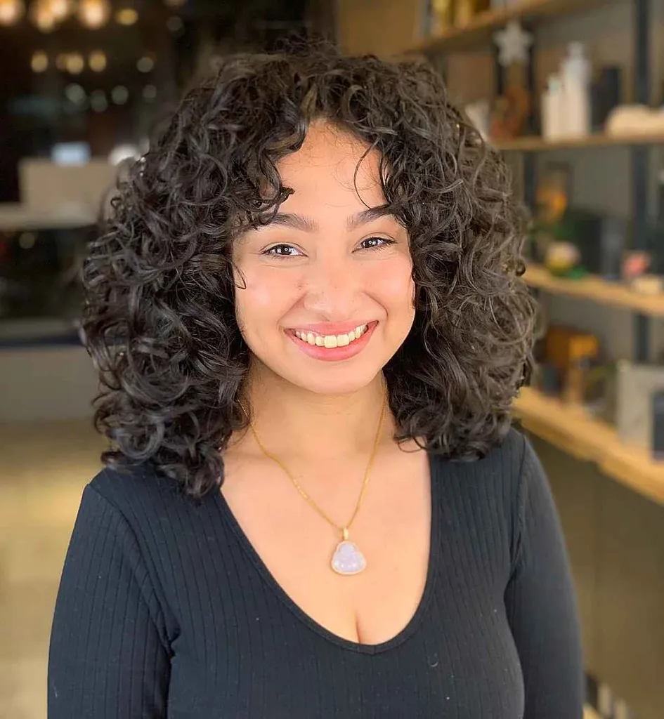 커튼 프린지가 있는 중간 길이의 컬리 컷' title=