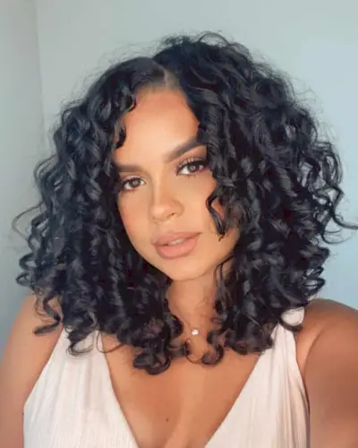 Naturally curly mid-length cut for a round face