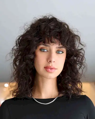 Messy and Frizzy Curly Cut with Fringe for women with shoulder-length hair