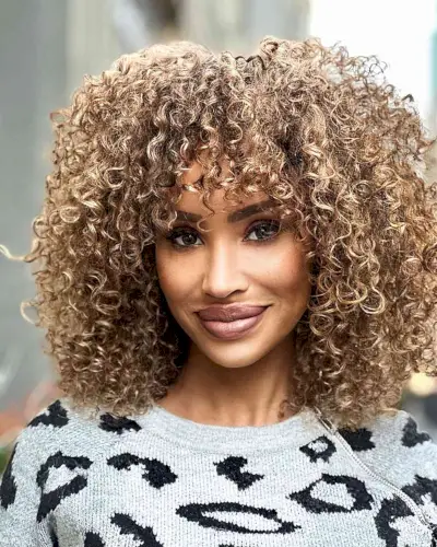 Beautiful Golden Curls and Bangs at shoulder-length with bangs using rezo cut technique