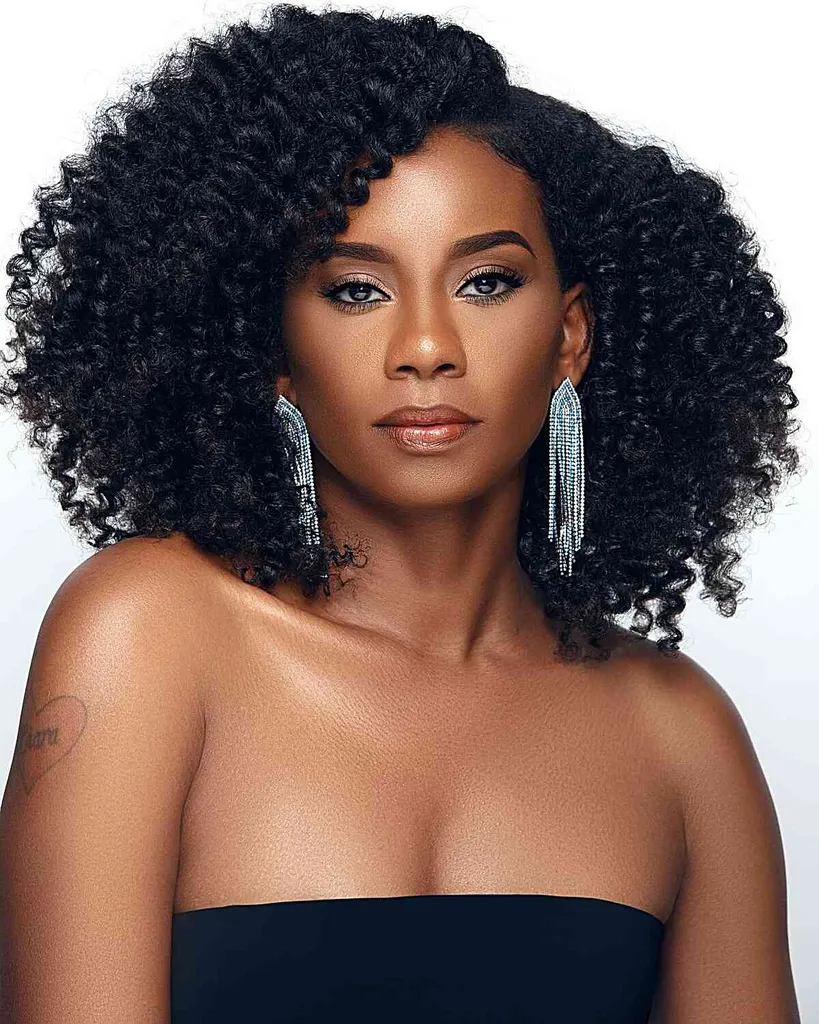 אישה עם גזרת Cadō מעוגלת לשיער מפותל שחור המספקת מסגור אלגנטי וסגנון נפח מתוחכם.' title=