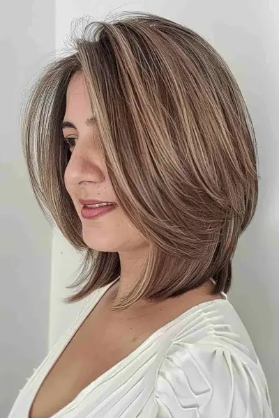 Dimensional collarbone-length graduated long bob with face-framing highlights.