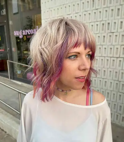 Face-framing peekaboo pink highlights for blonde hair