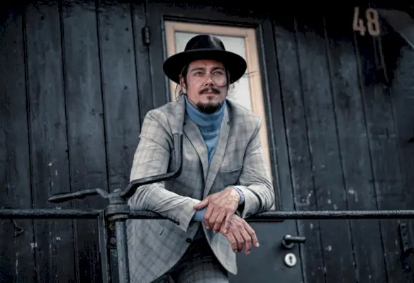 Chris bærer hat Stetson, jakkesæt Selected Homme og sweater Bruno Banani.