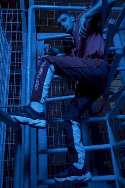 Nicolò ma na sobie spodnie Carhartt i buty Nike.