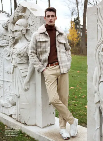 Robbie는 재킷 Native Youth, 터틀넥 Salvatore Ferragamo, 바지 Banana Republic, 벨트 Coach, 부츠 Maison Margiela를 착용합니다.