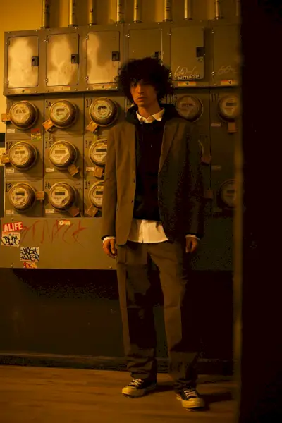 Liam veste camisa Gosha Rubchinskiy, moletom Alternative Apparel, sapatos Converse, jaqueta e calça Lemaire.