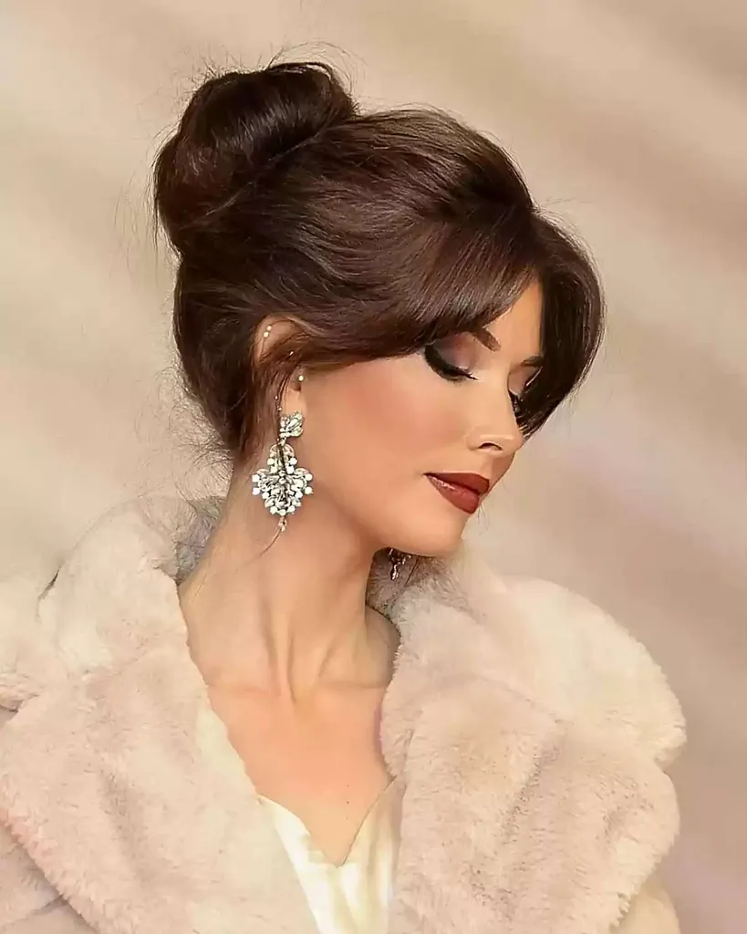 커튼 프린지가 있는 갈색 머리의 부드러운 업스타일' title=