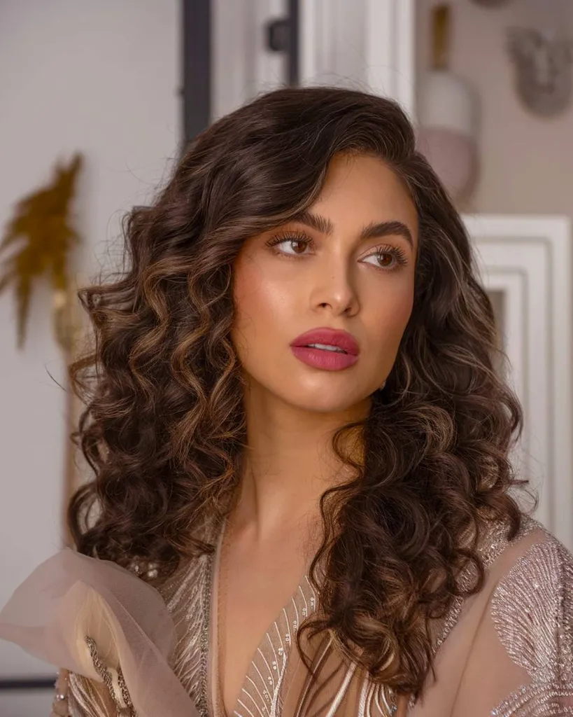Objemné priliehavé kučery s hlbokou bočnou časťou, ktorá dodáva definíciu a pôvab pre odvážny kučeravý glam vzhľad' title=