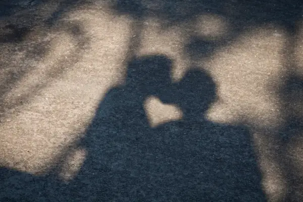 Shadow of a couple Shadow on a concrete floor of a couple kissing. Between their respective shadow appears a heart, shaped by the sun light.