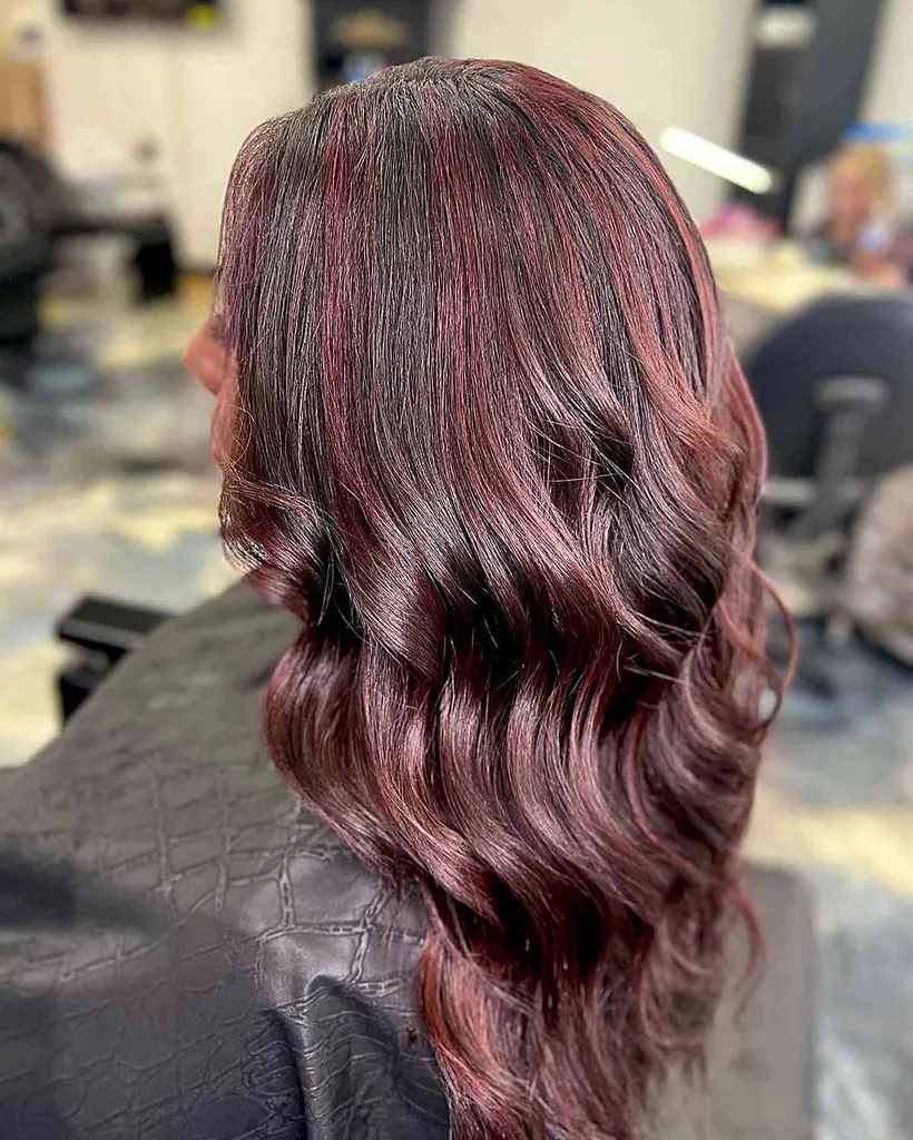 Mörkbrunt vågigt hår med rödtonade höjdpunkter' title=