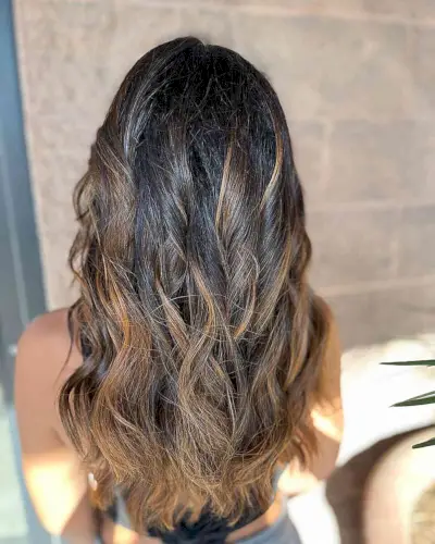 Warm Caramel Balayage Highlights and Long Waves for Black Tresses