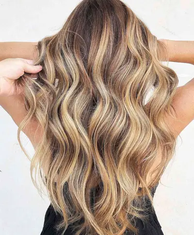 Butterscotch Bronde Hair Color for women with long wavy hair