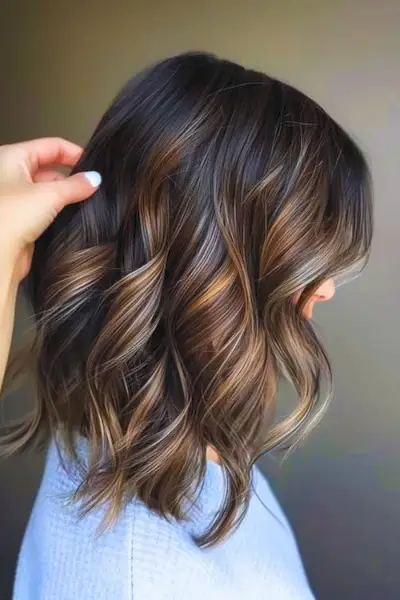 Jasná babylights na tmavě čokoládově hnědé barvě vlasů.
