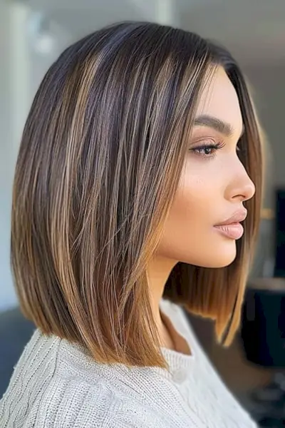 Tmavě hnědý účes cappuccino s tlumenými blond odlesky.