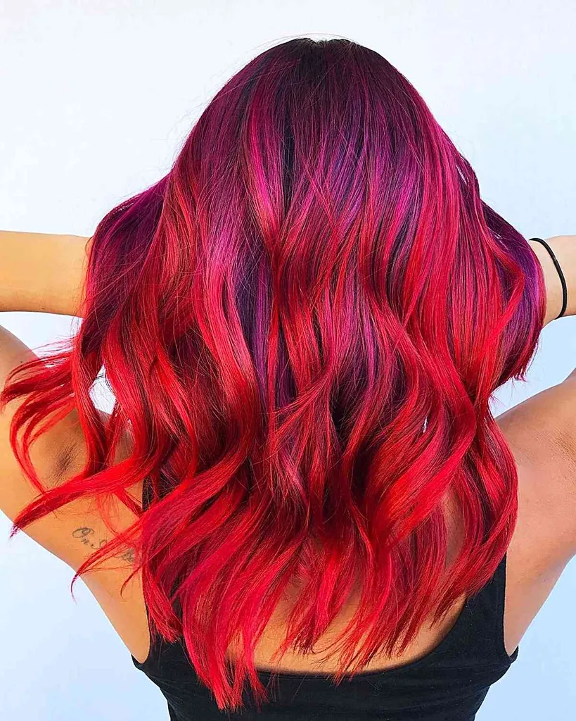 Impressionante cor de cabelo vermelho brilhante e vívido Balayage em cabelos ondulados de comprimento médio' title=