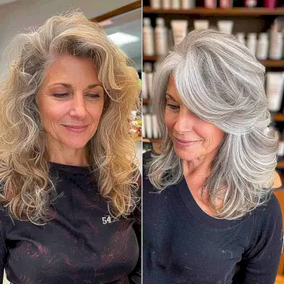 Silver lowlights blending into natural gray roots on wavy mid-length hair
