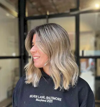 Shoulder-Length Light Blonde Balayage Hair with Black Roots and Subtle Layers