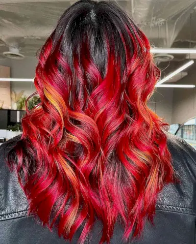 Fiery Red Balayage on long wavy hair with black roots