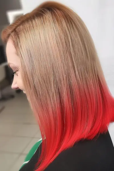 Medium-length blunt cut with reverse blonde to red ombre styling