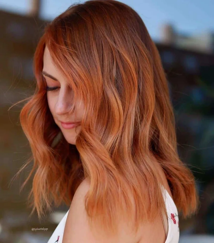 Skulderlangt rødt rødbrunt hår med høydepunkter' title=