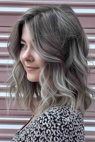 Medium-length wavy bob with natural-looking silver babylights and darker roots