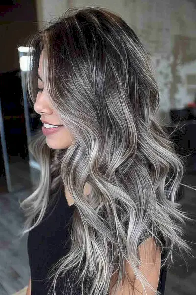 Long wavy hairstyle with a silver metallic gradient perfect for adding volume to dense hair